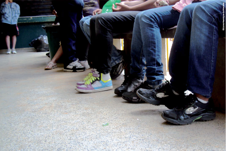 A fotografia mostra vários alunos sentados, esperando.