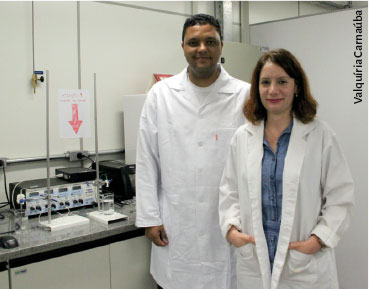 Foto dos dois pesquisadores, eles estão de jaleco, em um laboratório