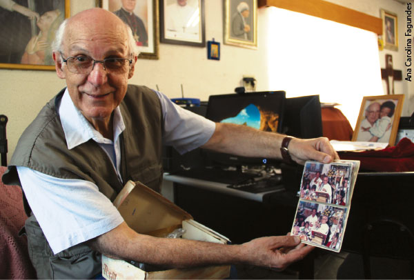 Julio Lancellotti mostrando um álbum de fotografias