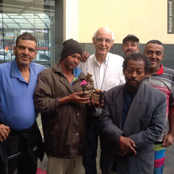 Julio Lancellotti com moradores de rua - um deles segura a imagem de São Francisco 