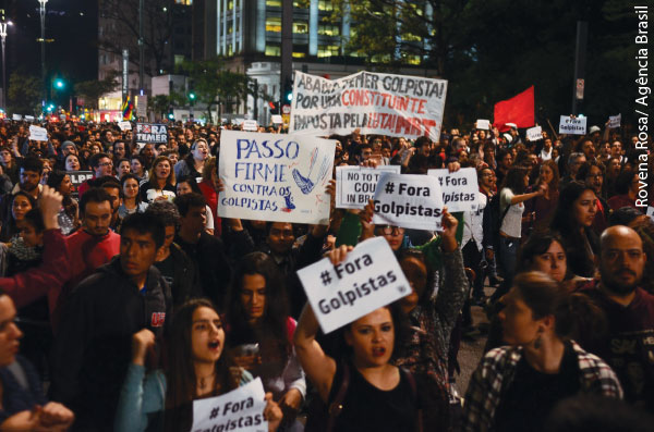 Foto de um protesto, as pessoas seguram cartazes com os dizeres Fora Golpistas 