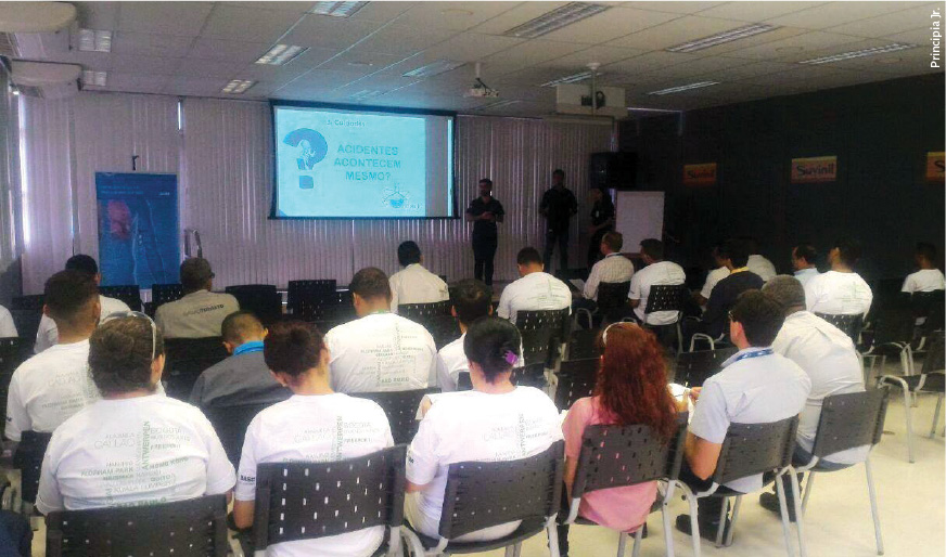 Sala com várias pessoas assistindo uma palestra