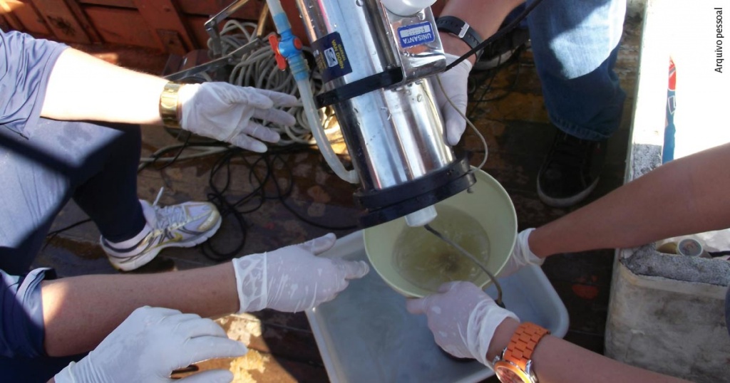 A imagem mostra vários pesquisadores com luvas processando água coletada