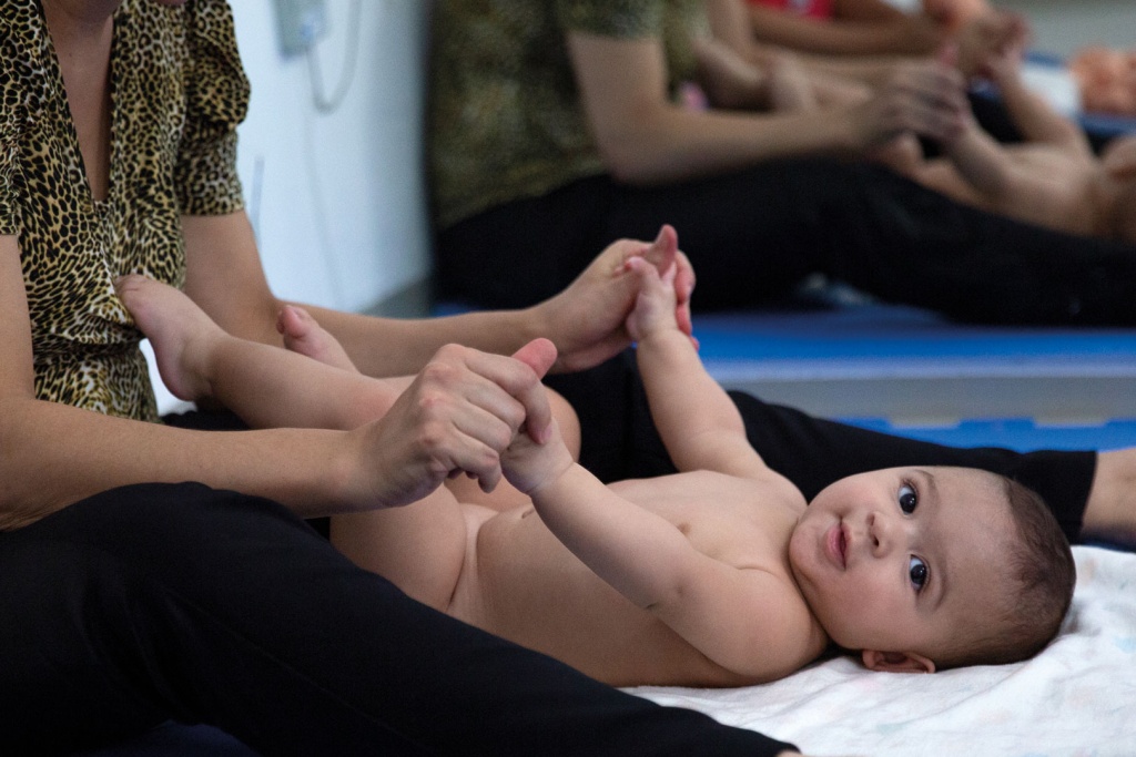 Imagem de um bebê deitado entre as pernas de sua mãe