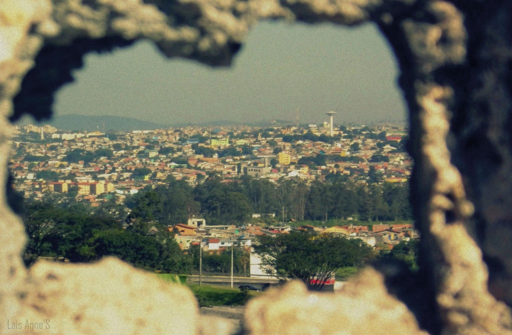 Um imagem de cidade vista através de um buraco na parede