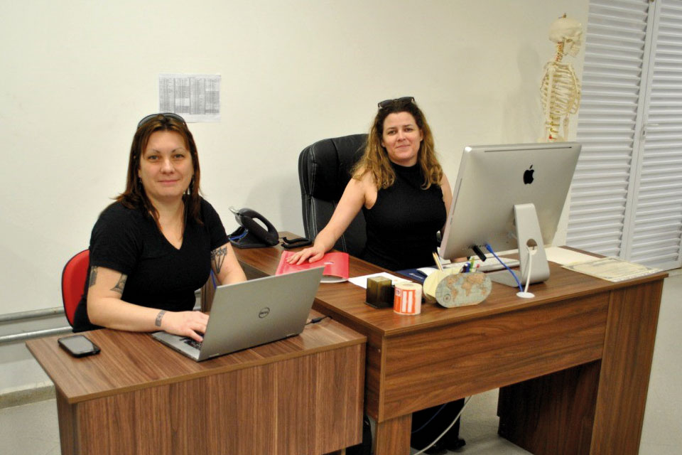 Pesquisadoras sentadas em frente a computadores Camila Diogo de Souza e Claudia Plens