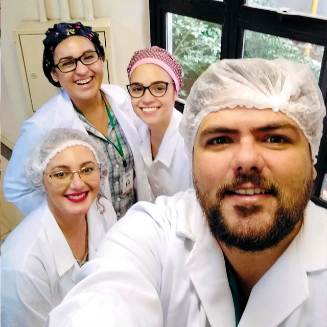 Selfie dos pesquisadores, estão todos de jaleco e touca