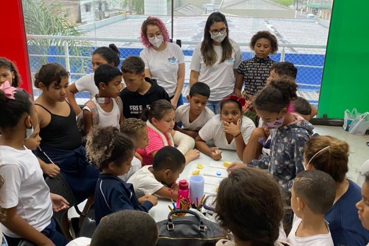 Os(as) cientistas da maré sentados em volta de uma mesa durante as atividades