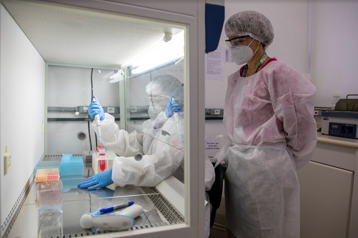 Pesquisadoras paramentadas em um laboratório manipulando equipamentos