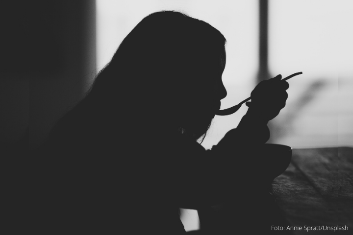 Perfil em preto e branco de uma menina se alimentando