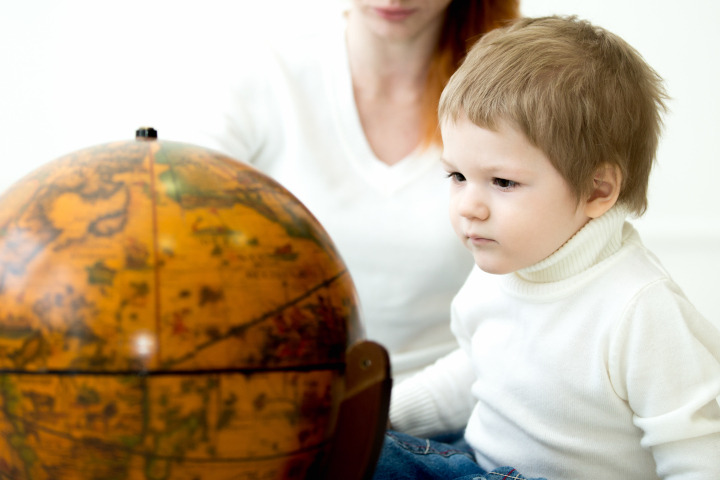 Bebê olhando para o globo terrestre